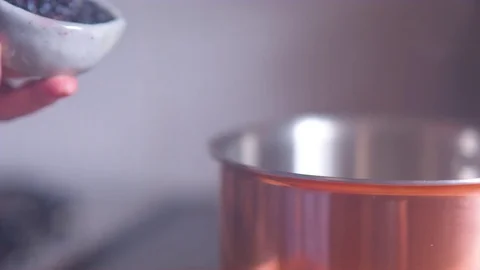 Woman's hand putting black pepper in pan Vidéo 76138449
