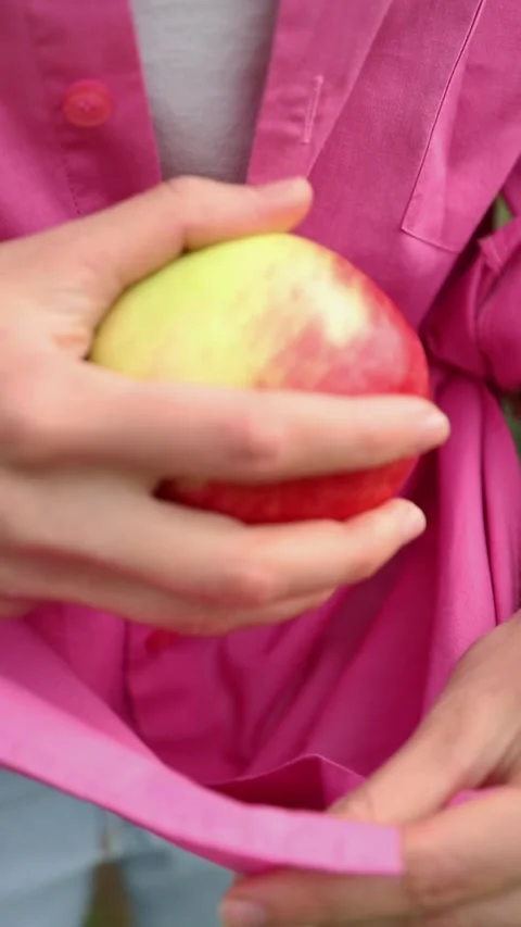 Woman's hand putting ripe apple in her shirt Video stock 345935914