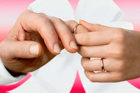 Woman's hand putting on a wedding ring on a man's finger Foto stock
