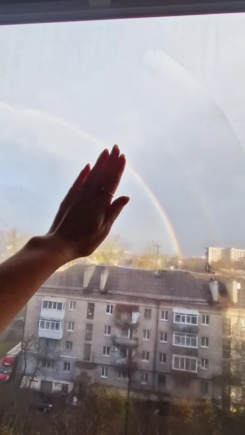 Womans Hand Reaching for Double Rainbow Through Window Over City Stock Footage 325223014