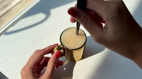Woman's hand with red manicure picking up a cup of freshly brewed coffee Stock Footage 342069544