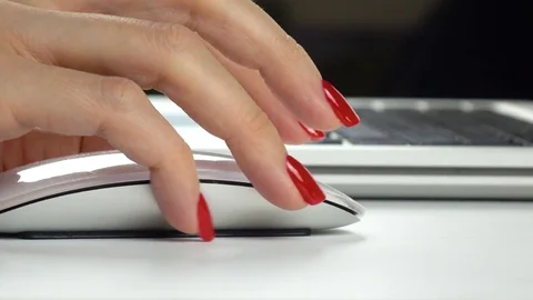 Woman's hand with red manicure using a wireless computer mouse. Close-up Video stock 84757388