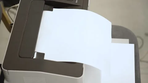 Woman's hand with red nail polish taking a printed sheet of paper from a printer Stock Footage 346186806