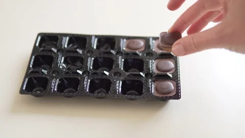 A woman's hand returns the ode to the chocolate candy in the package Stock Footage 234396252