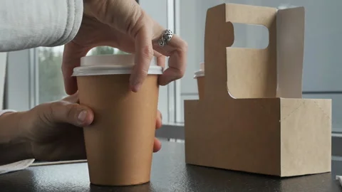 Woman's hand with a ring on a finger opens a glass of hot tea in a cafe Video stock 161590657