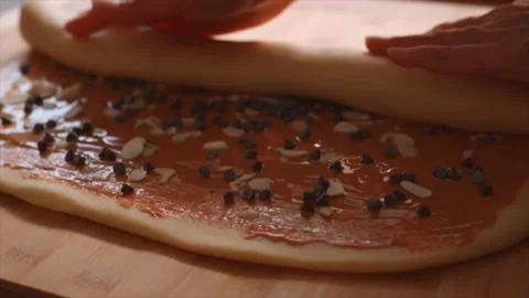 Woman's hand rolling out dough with chocolate cream Stock Footage 229705162