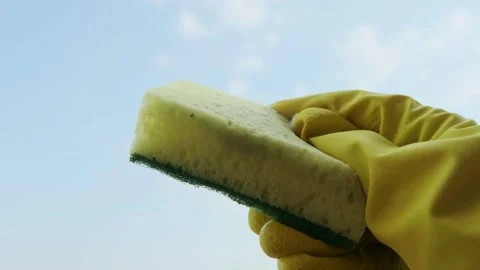 Woman's hand in rubber gloves for safe home cleaning, holding a sponge ready for Stock Footage 301307600