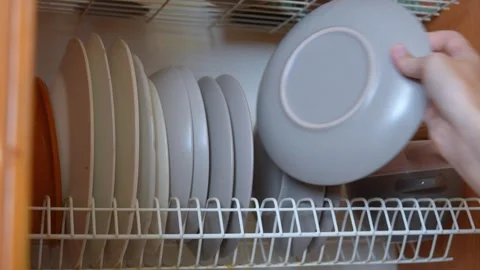 Woman's hand selecting plate from kitchen dish rack Vidéo 329103222
