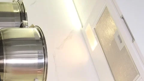 A woman's hand selects a mode on the hood, stands near a kitchen appliance in a Stock Footage 250354570