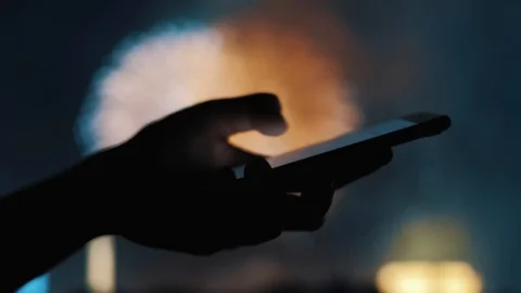 Woman's hand sending a message on a mobile phone with fireworks in background Stock Footage 92200785