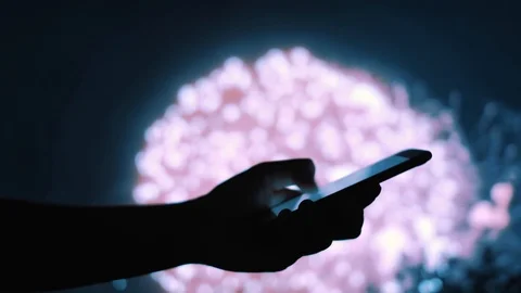 Woman's hand sending a message on a mobile phone with fireworks in background Stock-Footage 92200919