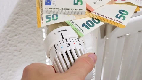Woman's hand sets thermostat of heating system to low temperature. Radiator Stock Footage 204804441