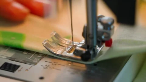 A woman's hand sews on a sewing machine, close-up. Warm hobby atmosphere Stock Footage 272415566