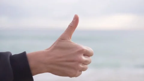 A woman's hand shows class against the background of the sea Stock Footage 236468650