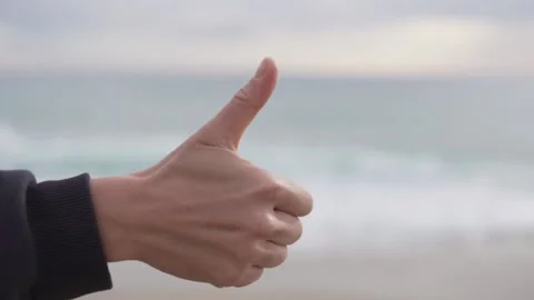 A woman's hand shows cool against the background of a blurry sea Stock Footage 236534813