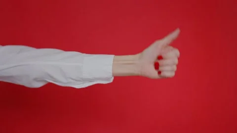 Woman's hand shows finger up gesture on red background. Copy space for Stock-Footage 131061908