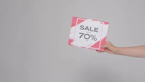 The woman's hand shows the poster with the discount offer Stock Footage 282917018