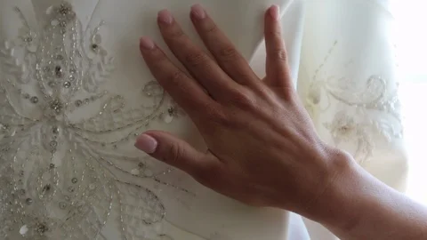 Woman’s hand slowly moving down wedding dress Vídeos de archivo 107265484