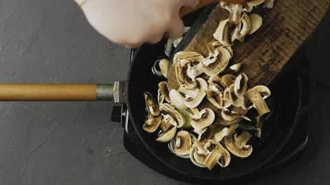 A woman's hand with a spatula drops the chopped champignons with a spatula from 库存影片 170903463