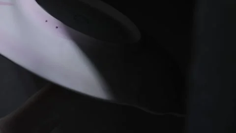 A womans hand sprays icing on a large plate. Close up. Grayscale Video stock 130526252