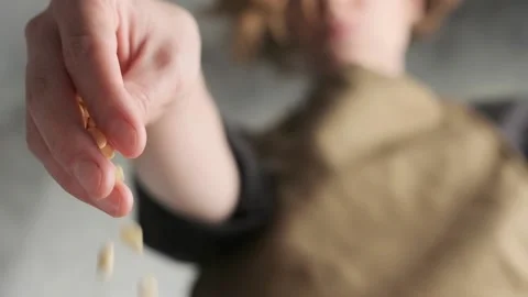 Woman's hand sprinkles pine nuts salad. Close-up in slow motion, Stock Footage 157741086