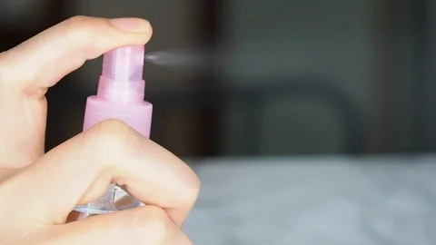 Woman's hand spritzing liquid from spray Stock Footage 115639494