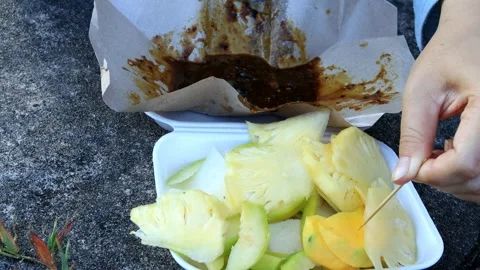 Woman's hand is stabbing rujak fruit to eat Video stock 280893671