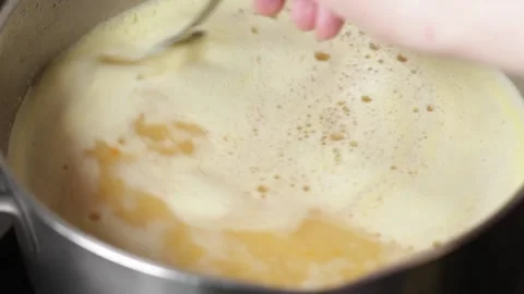 A woman's hand stirs the boiling soup with a spoon. Stock Footage 201338098