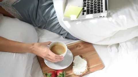 Woman's hand take cup with coffee. Morning breakfast in bed. Stock Footage 168514057