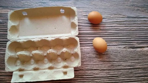 A woman's hand takes a beige egg from an egg box Stock Footage 147659698
