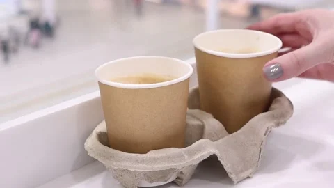 Woman's hand takes coffee from the table. Coffee to go. Stock-Footage 233527806