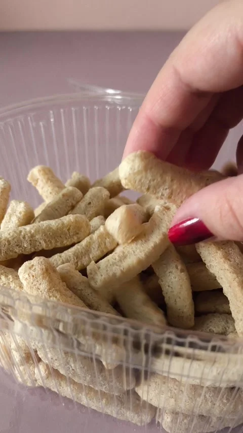 A womans hand takes crispbread from a plastic container with crispbread. Whole Stock Footage 324696229