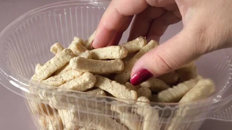 A womans hand takes crispbread from a plastic container with crispbread. Whole Stock Footage 324769990