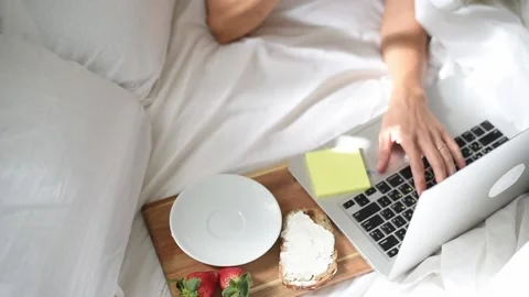 Woman's hand takes of cup coffee in morning in bed. Stock Footage 168514093