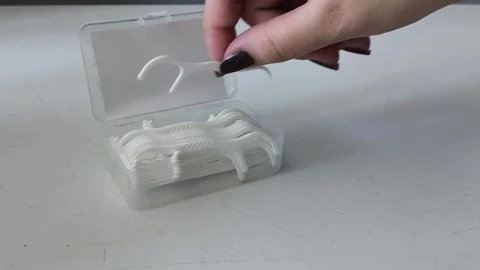 A womans hand takes the flosser from the container and places it on the table Vidéo 329969439