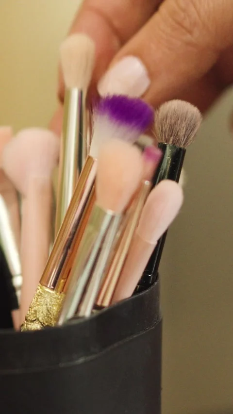 A woman's hand takes a makeup brush from a black container. Stock Footage 270081441