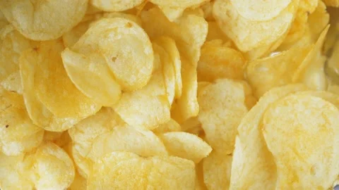 A woman's hand takes one crispy snack. A pile of unhealthy food lies on the Stock-Footage 219920276