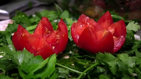 A woman's hand takes one of the tomatoes cut into a rose shape Stock Footage 341765511
