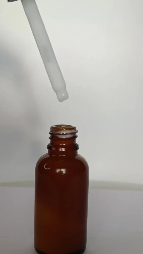 A woman's hand takes out a pipette with white serum from a dropper bottle Stock Footage 297481953