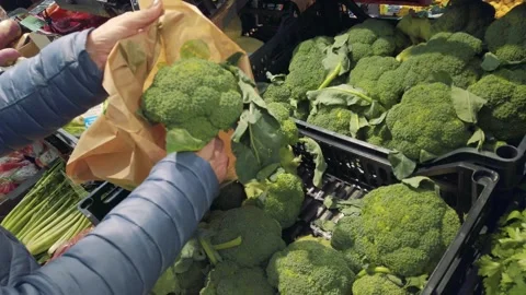 Woman's hand taking broccoli from box on shelf and Stock Footage 257205236