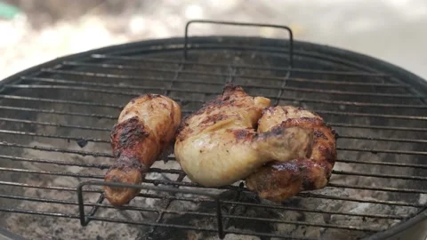 Woman's hand is taking off chicken legs out of barbecue grid Stock Footage 154295821