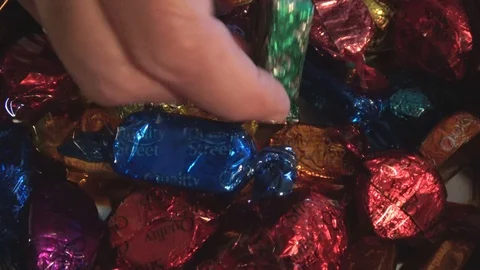 A Woman's Hand Taking Chocolate Wrapped Candy Extreme Close Up Stock Footage 117361069