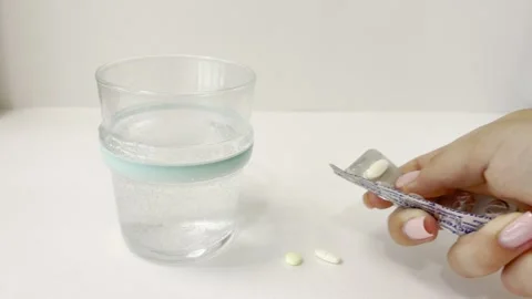 Woman's hand taking daily dose of vitamin pills and supplements from a blis.. Stock Footage 335141614