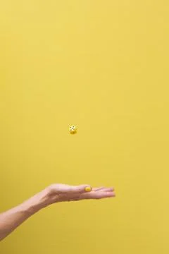 Woman's hand throwing the die in the air Stock Photos