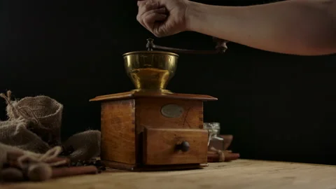Woman's hand throws coffee beans into vintage coffee mill for grinding. Wooden Stock Footage 136815129