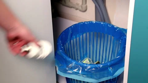 A woman's hand throws a fluorescent light bulb into a mixed waste bin. Full HD Stock Footage 141611409