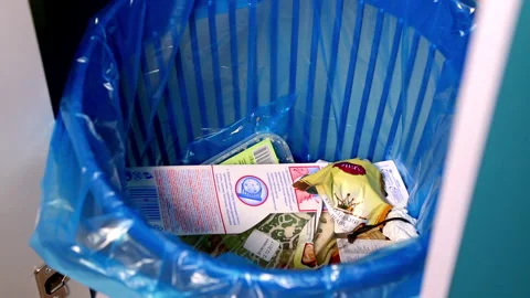A woman's hand throws a fluorescent light bulb into a mixed waste bin. Full HD Video stock 141611484