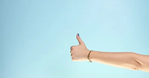 Woman's hand thumb up on a blue background Stock Footage