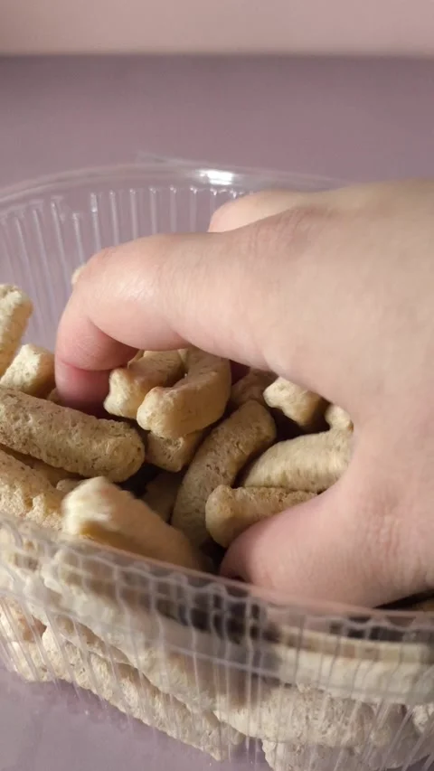 A womans hand touches crispbread in a plastic container. Whole grain breads Stock Footage 324695872