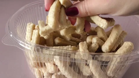 A womans hand touches crispbread in a plastic container. Whole grain breads Stock Footage 324696364
